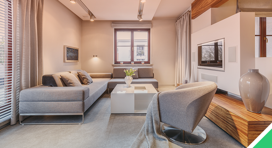 Elegant modern living room with gray sectional sofa, sleek armchair, white lacquered coffee table, wood-accented TV unit, and minimalist decor, designed by SKDesignz interior studio.